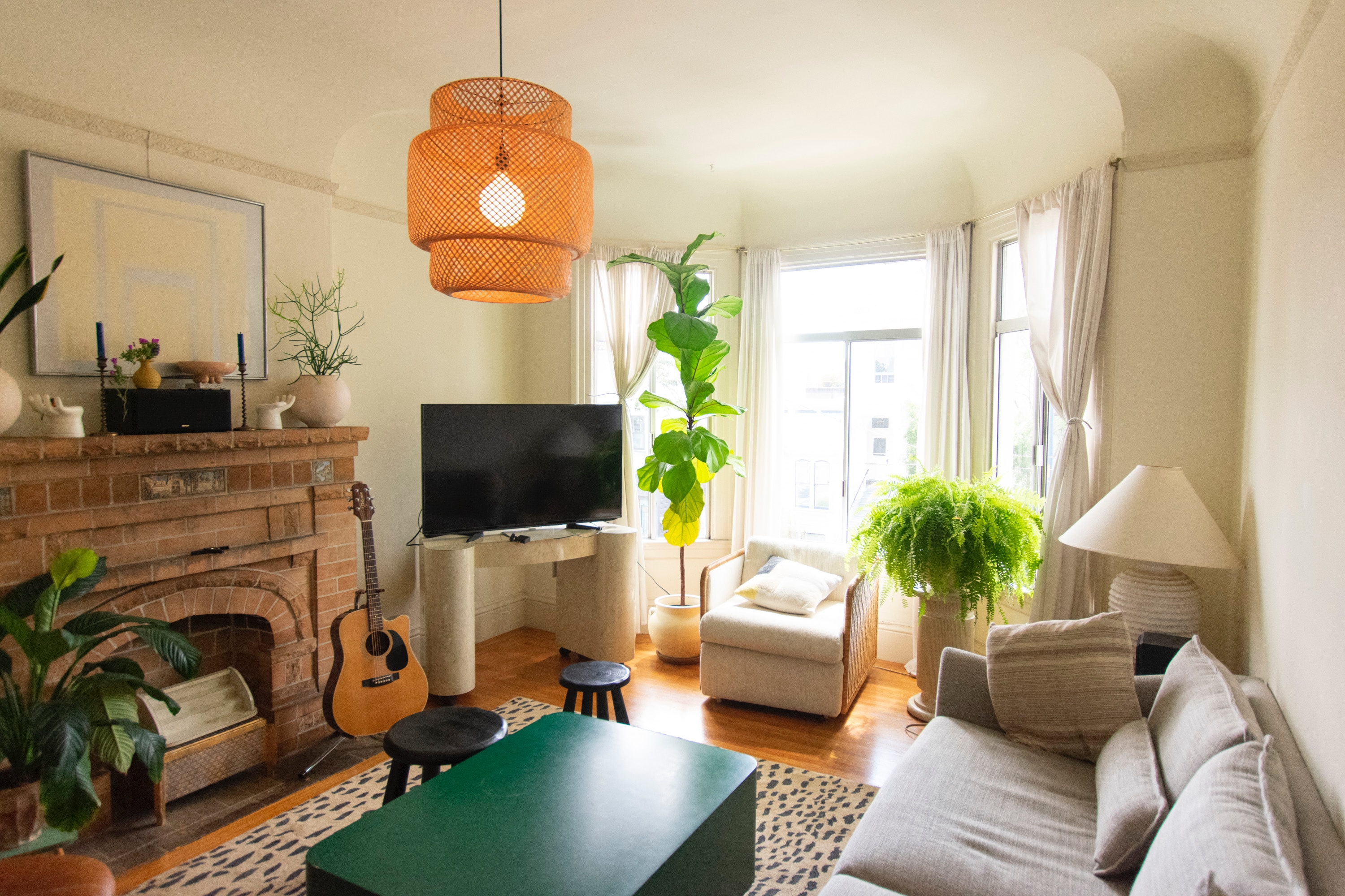 organic apartment living room. Green plants near a window and lots of greens and natural color.
