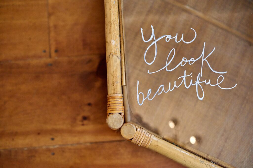 wood table with the affirmation "you look beautiful" written in white on a tray. 