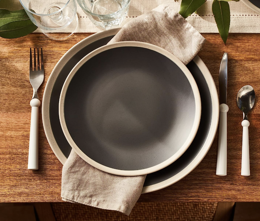 brown plates with beige ring on the exterior of the plate. The plate is on a table with flatware and a napkin.
