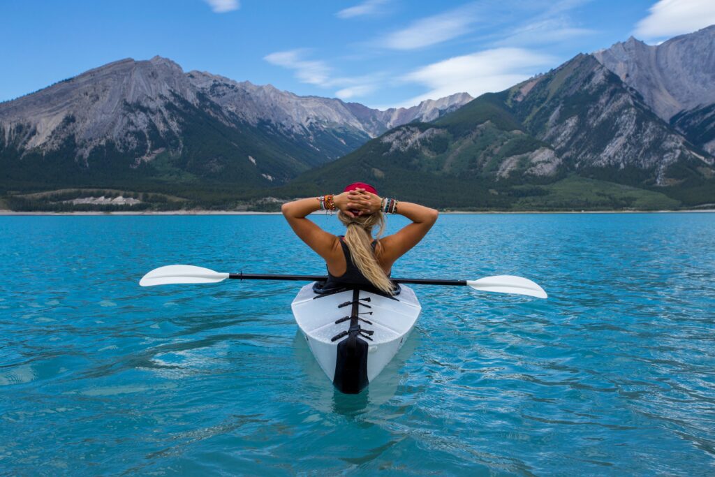woman canoeing in a body of water in Canada. Canada is one of the best fall travel destinations
