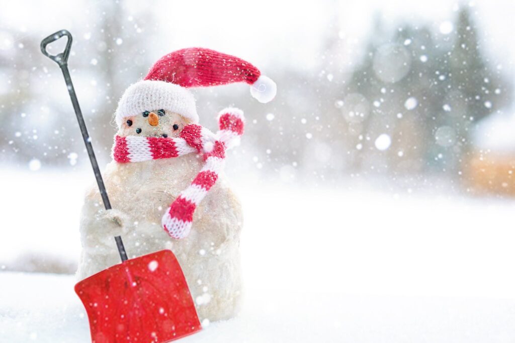 Snowman Holding Shovel. Building a snowman can help you get into the holiday spirit.