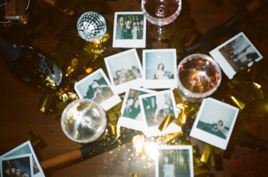 Wine Glasses And Pictures On Table on New Year's Eve. The perfect time to make new year resolutions.